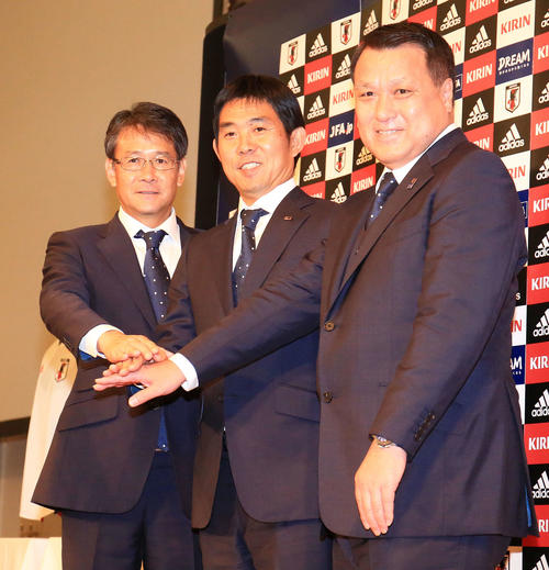 2018年7月　サッカー日本代表新監督就任会見を行い田嶋幸三会長（右）、関塚隆技術委員長（左、当時）と手を合わせる森保一監督